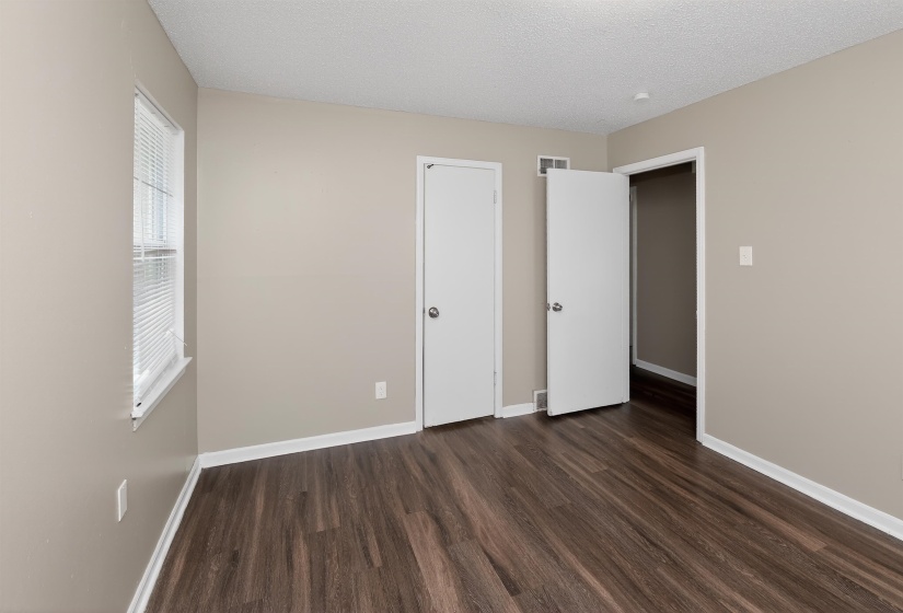 Interior space featuring wood-finish flooring, neutral wall paint, white trim, and a white ceiling