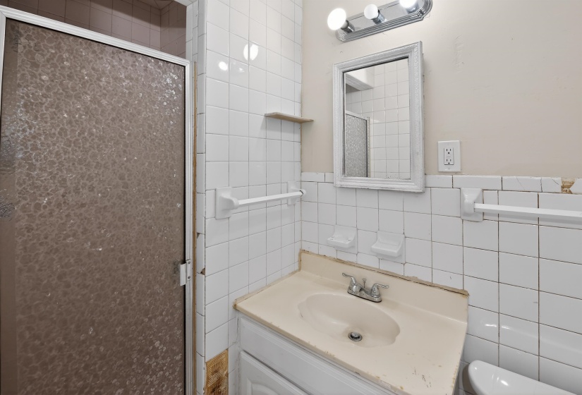 Bathroom with tiled walls and a shower enclosure