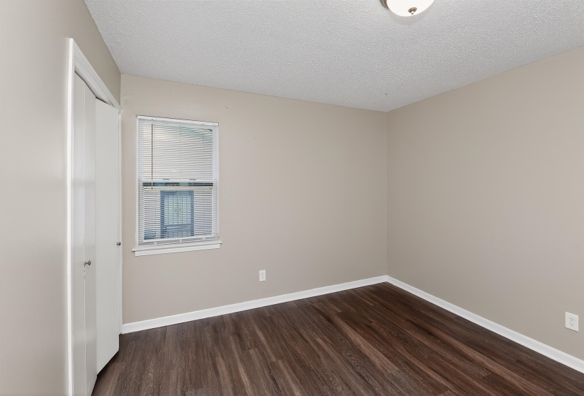 Interior space featuring wood-finish flooring, neutral wall tones, and white baseboards