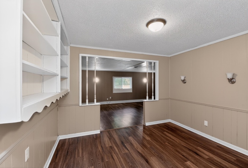 Interior space featuring wood-finish flooring, built-in shelving, sconce lighting, and a neutral color palette