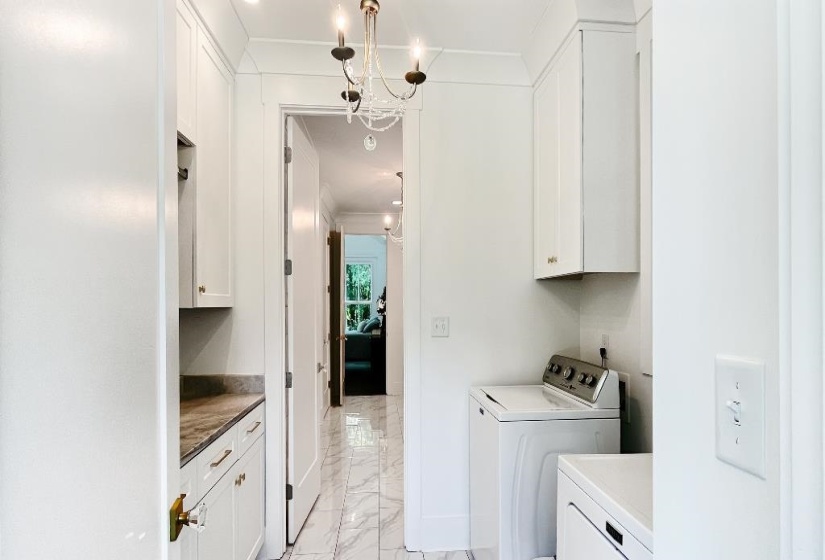 Laundry area featuring white cabinetry, a stone-finish countertop, and a chandelier-style light fixture