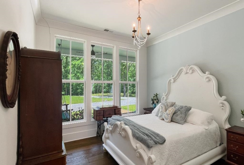 Bright interior featuring dark wood-finish flooring, white crown molding, and light-colored walls