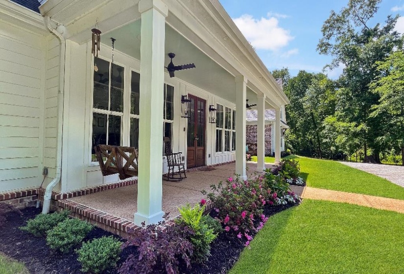 Expansive covered porch featuring a painted ceiling, recessed lighting, and a dark wood entry door