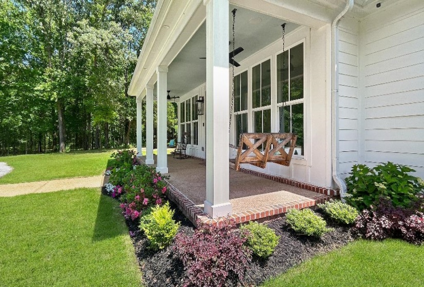 Covered front porch featuring white columns, a blue ceiling, and a visible ceiling fan
