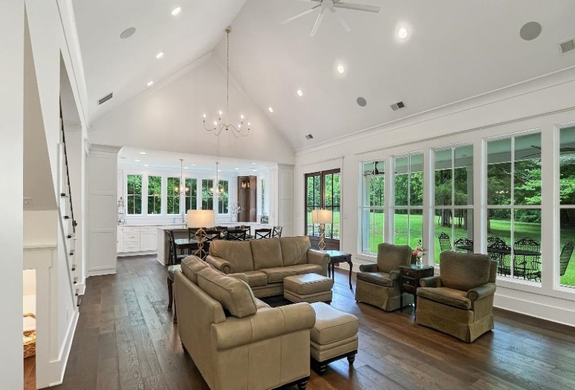 Spacious open-concept living area featuring a vaulted ceiling and dark wood-finish flooring