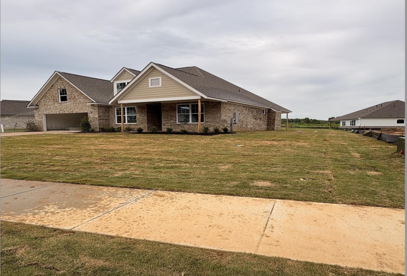 Brick and siding exterior featuring multiple gables and a covered front porch