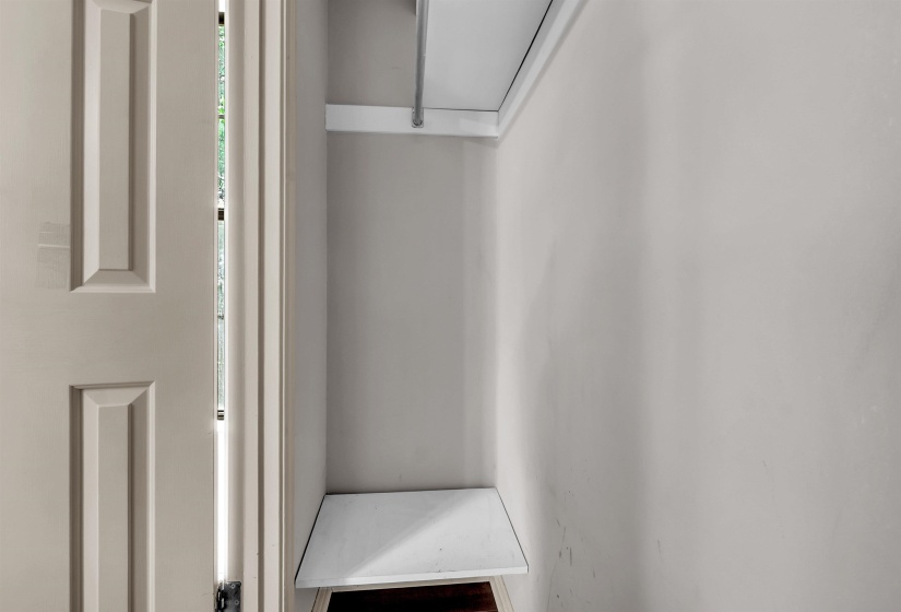 Recessed storage area featuring a built-in shelf and hanging rod