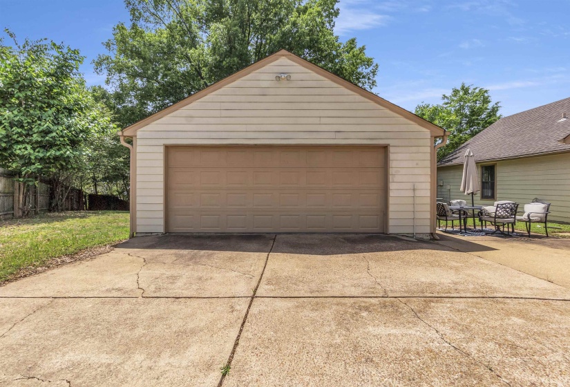 Detached two-car garage with a light-toned garage door and siding