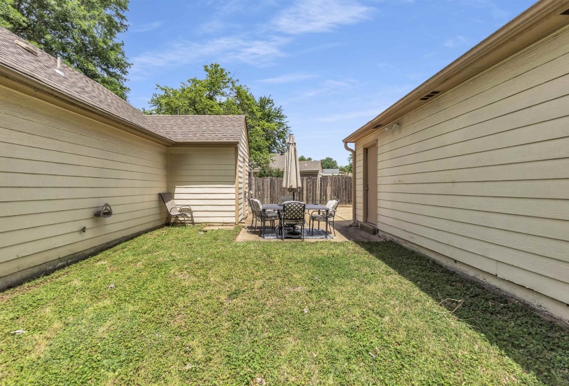 Rear patio area featuring a concrete surface and a wood privacy fence