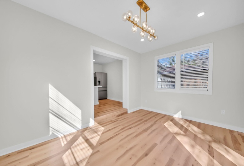 Unfurnished dining area featuring a chandelier, light wood finished floors, and recessed lighting