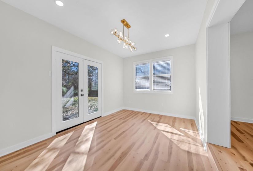 Unfurnished dining area with french doors, light wood-type flooring, recessed lighting, and a chandelier