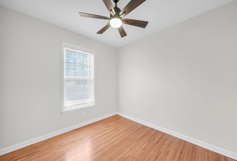Unfurnished room featuring wood finished floors and a ceiling fan