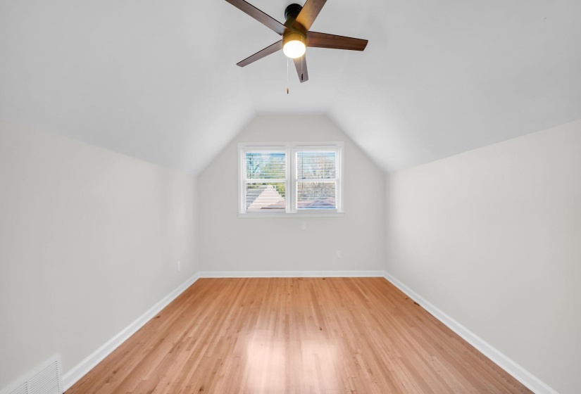 Bonus room with lofted ceiling, light wood-style flooring, and a ceiling fan