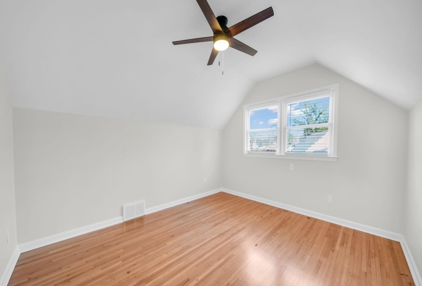 Additional living space with vaulted ceiling, wood finished floors, and a ceiling fan