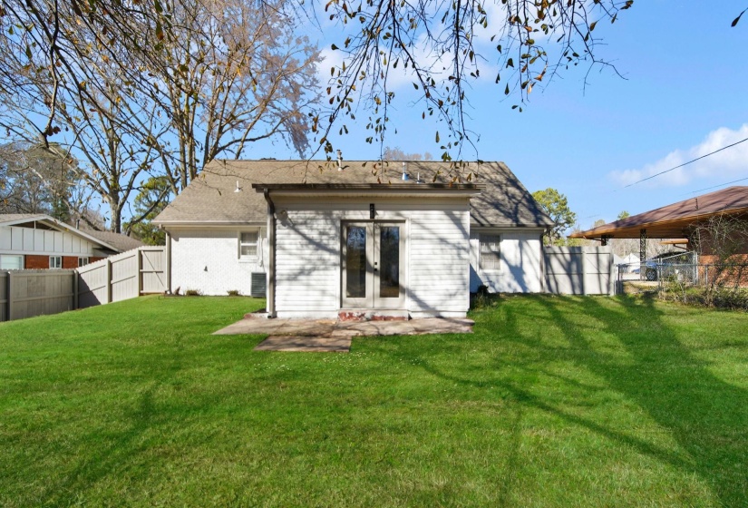 Rear view of house featuring a fenced backyard, french doors, a patio, brick siding, and roof with shingles