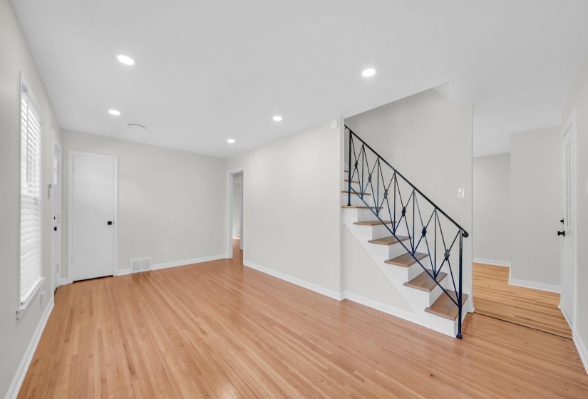 Unfurnished living room featuring stairs, recessed lighting, and light wood-style floors