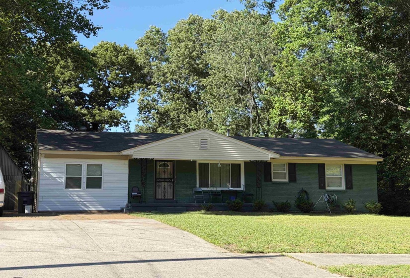 Ranch-style exterior with a dark green brick facade and white horizontal siding
