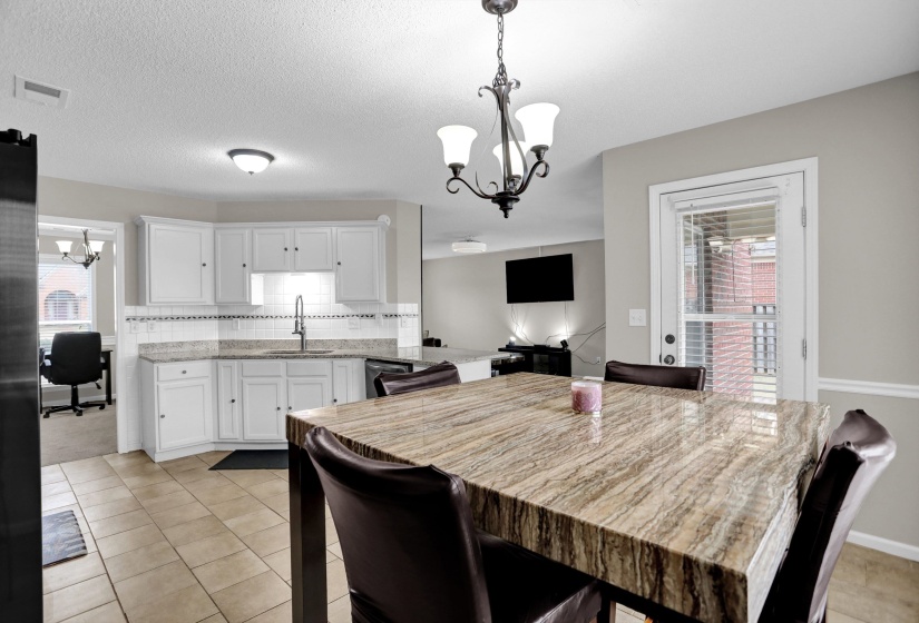 Dining room featuring a chandelier, a textured ceiling, light tile patterned flooring, and an office area
