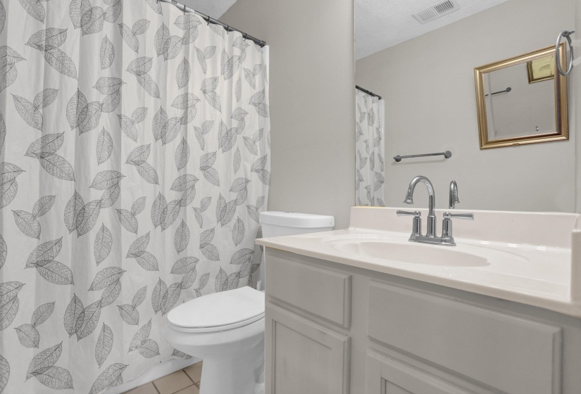 Full bathroom with vanity, curtained shower, and light tile patterned floors