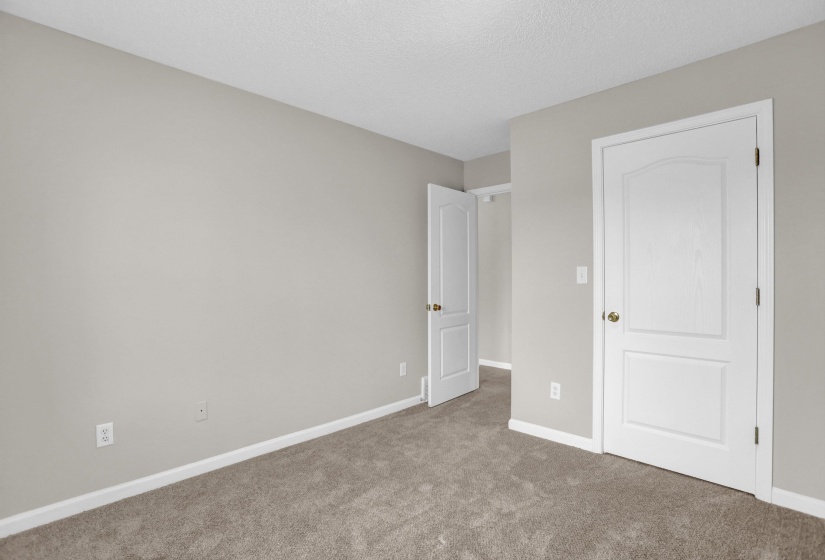 Unfurnished bedroom with carpet and a textured ceiling