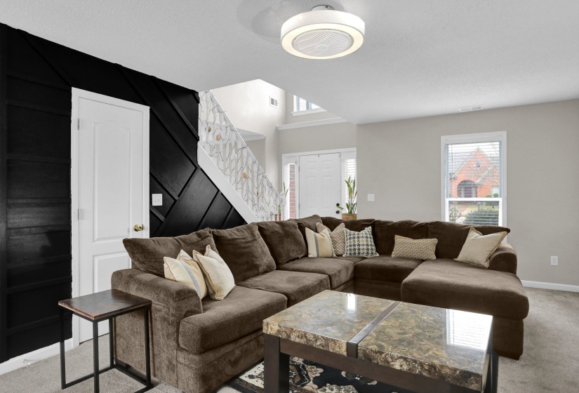 Living area with light colored carpet and stairs