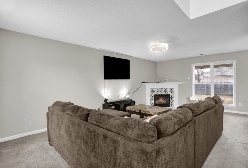 Living area featuring light colored carpet and a tile fireplace