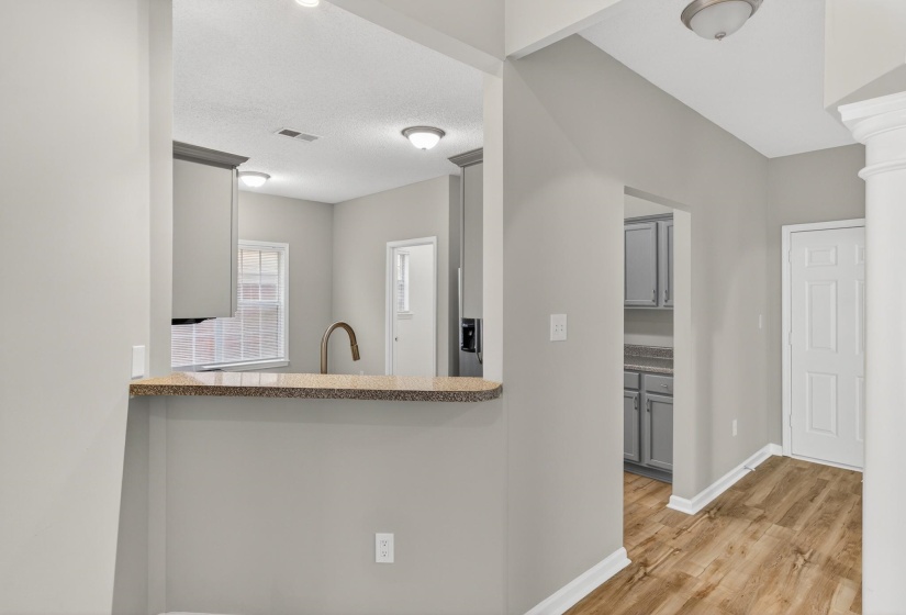 Breakfast bar with a stone-finish countertop, undermount sink, and gooseneck faucet