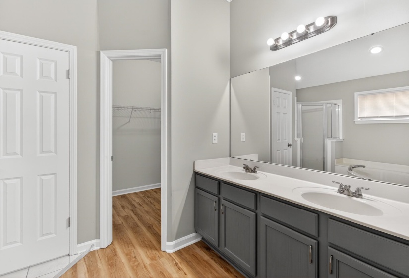Bathroom featuring a dual vanity with gray cabinetry, white countertops, and undermount sinks