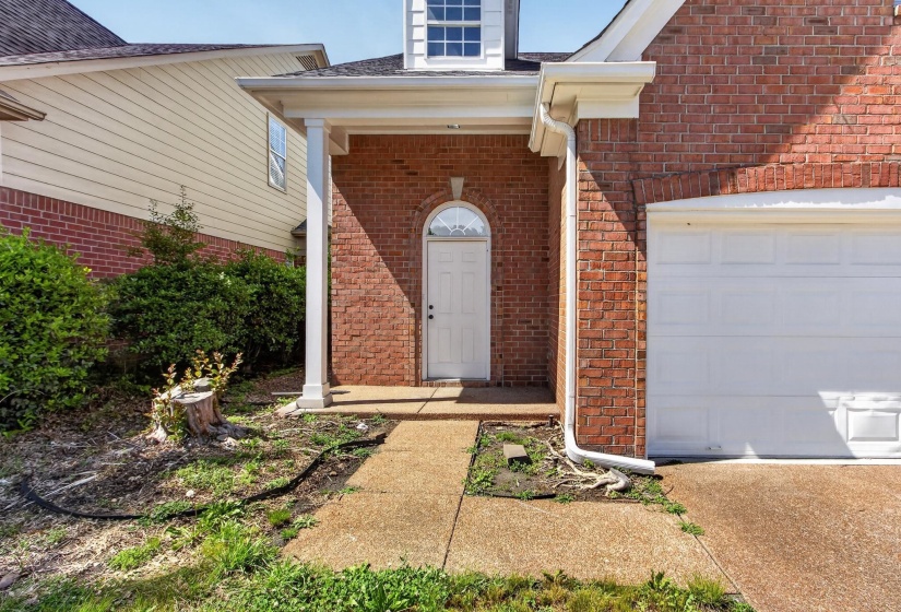 Brick facade home featuring a covered entryway with a column