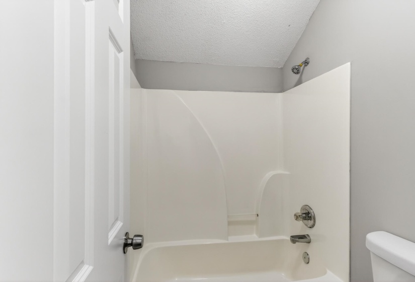White fiberglass tub/shower combination with chrome fixtures