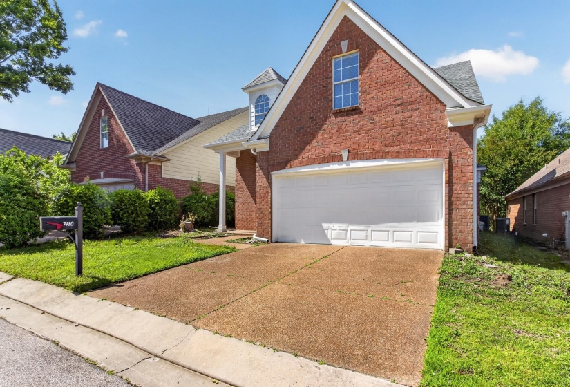 Brick exterior with dormer windows and an attached garage