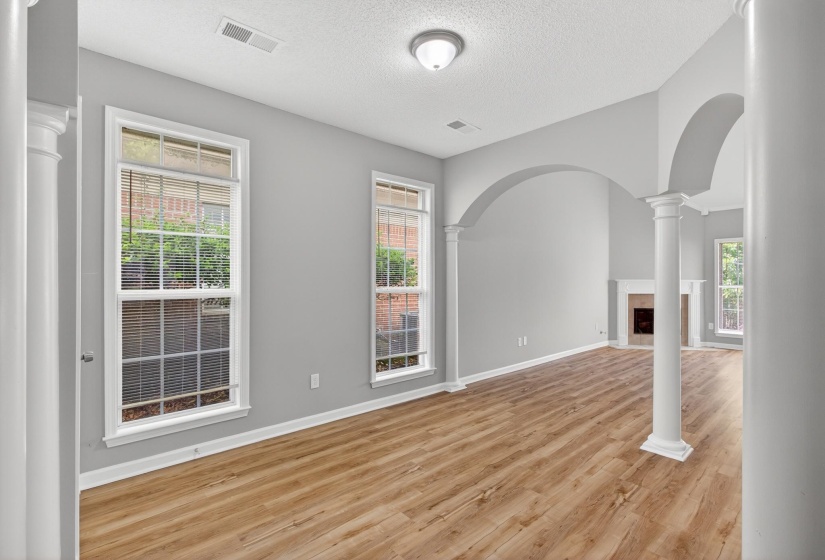 Spacious interior with wood-finish flooring, light gray walls, and multiple large windows