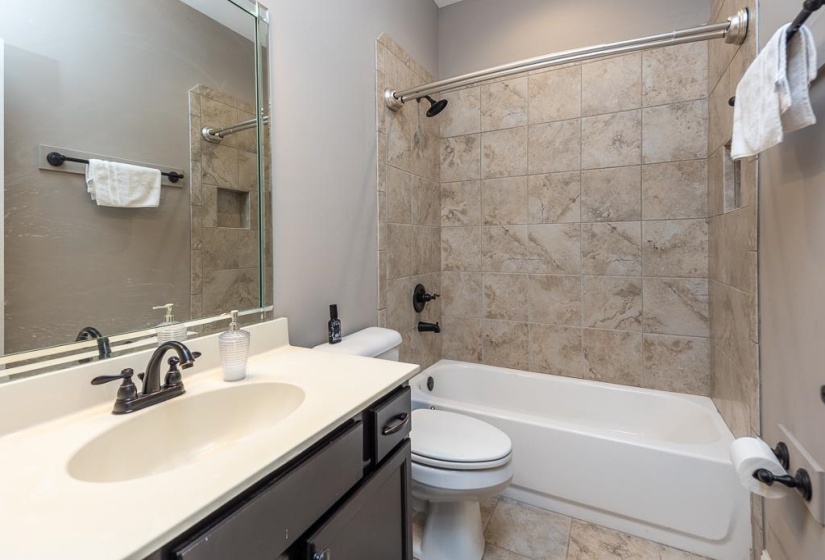 Bathroom featuring a tub and shower combination with tiled surround and an integrated niche