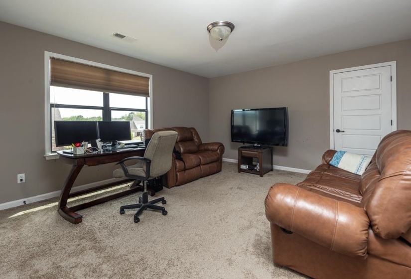 Spacious room featuring neutral carpeting and light gray wall paint