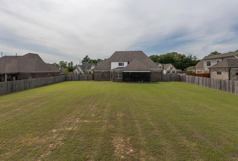 Expansive grass lawn with complete wooden privacy fencing
