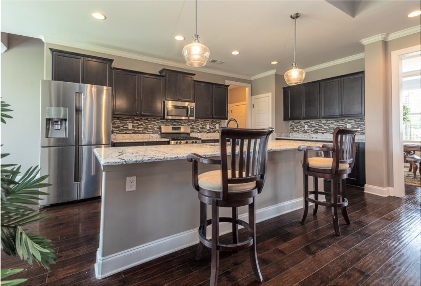 Kitchen featuring dark wood-finish flooring, dark cabinetry, and light-toned countertops