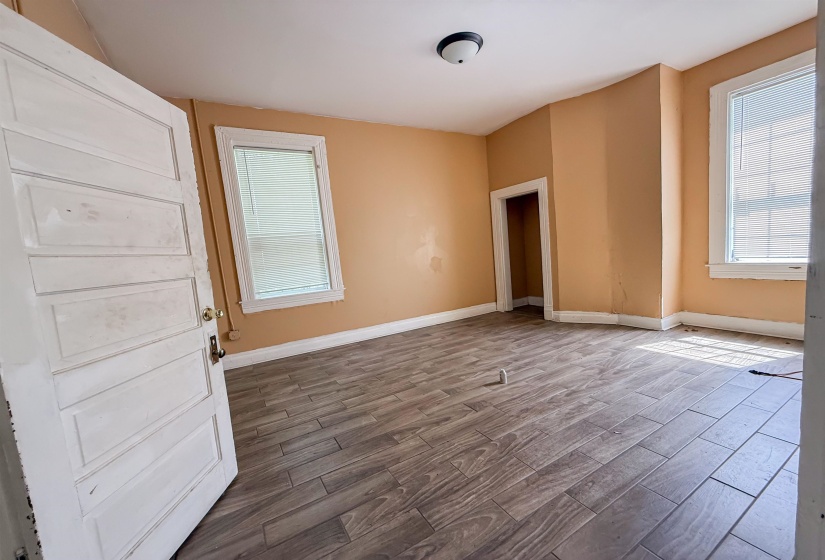 Room featuring wood-finish flooring, neutral wall tones, and multiple windows