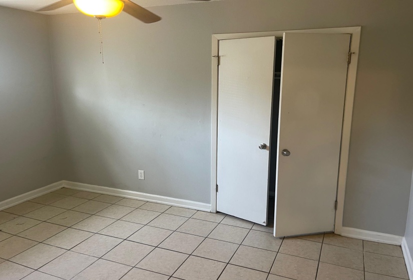 Spare room featuring light tile patterned floors, baseboards, and ceiling fan