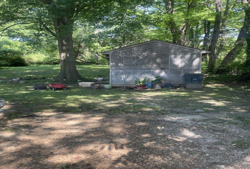 Gable-roofed outbuilding with a panelized exterior and an integrated utility box