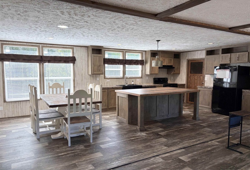 Kitchen with a central island featuring a wood-finish countertop, wood-finish flooring, and recessed ceiling lighting