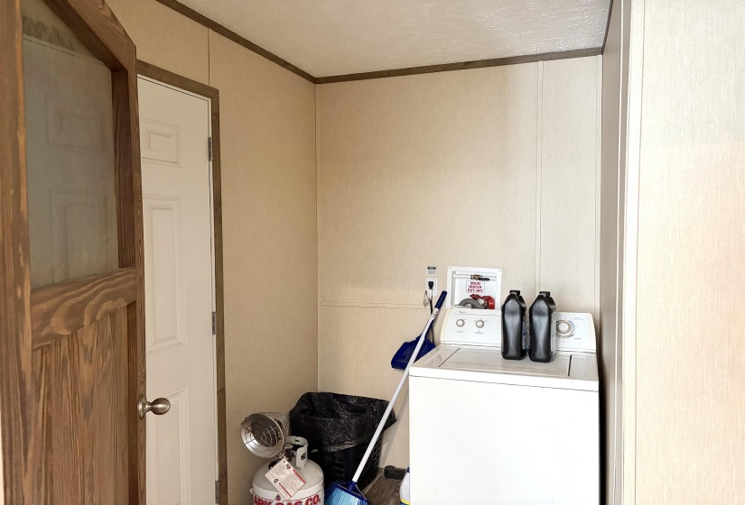 Laundry area featuring paneling walls and crown molding