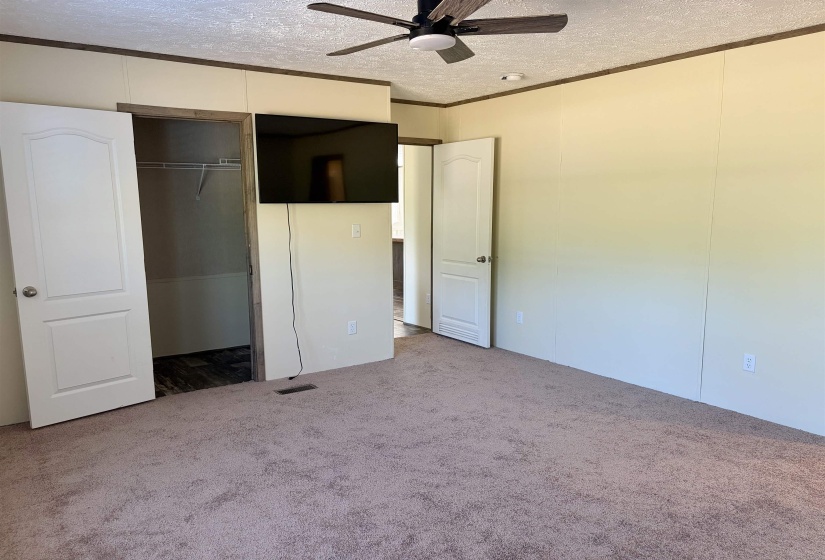 Spacious interior room featuring light-colored panel walls and a neutral carpeted floor