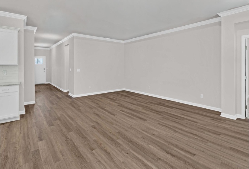 Unfurnished living room featuring ornamental molding and dark wood-type flooring