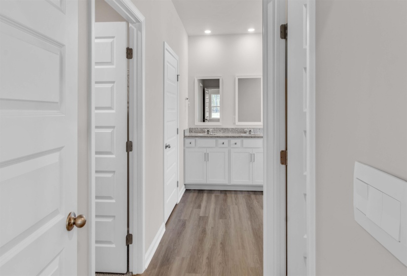 Bathroom featuring double vanity, light wood-style floors, and recessed lighting