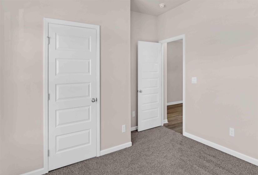 Unfurnished bedroom with baseboards and dark colored carpet