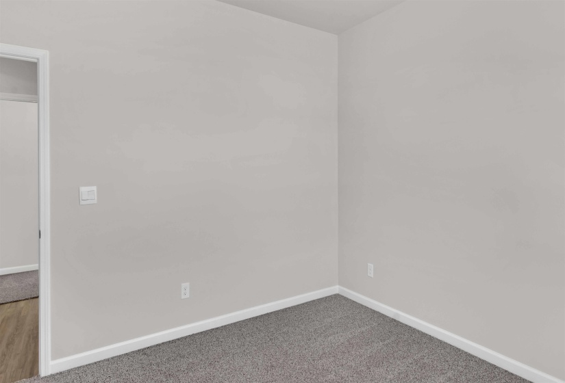 Carpeted spare room featuring baseboards