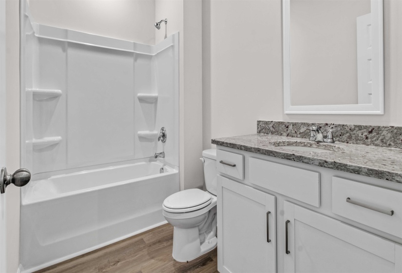 Bathroom with vanity, dark wood-style floors, and washtub / shower combination