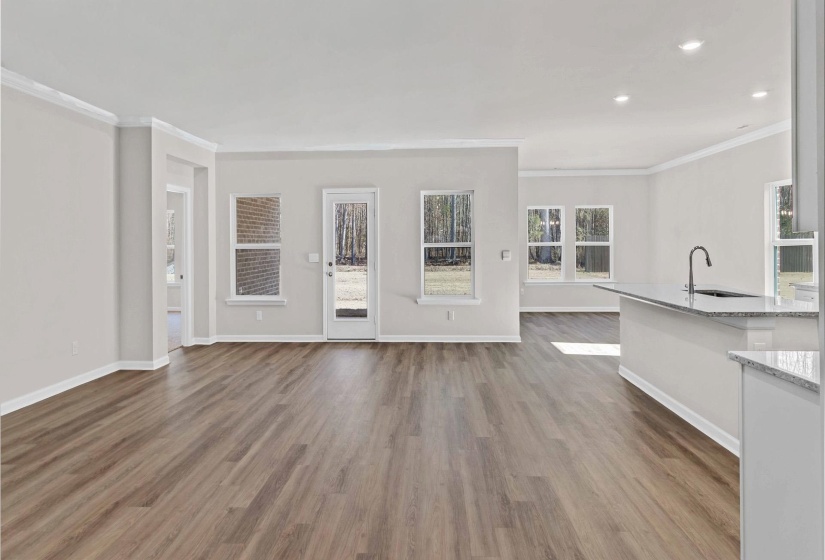 Unfurnished living room with dark wood-style floors and crown molding