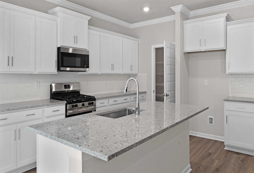 Kitchen with backsplash, light stone counters, stainless steel appliances, dark wood-style floors, and white cabinetry