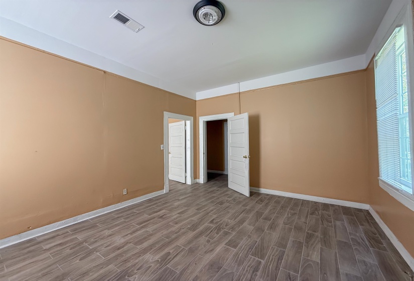 Interior space featuring wood-look tile flooring, neutral wall tones, white trim, and a ceiling-mounted light fixture